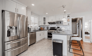 Los Gatos, CA: Modern kitchen with white cabinets, stainless steel appliances, and gray countertops staged for high ROI.