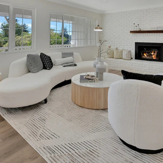 Palo Alto, CA – How Lighting Affects the Look and Feel of a Staged Luxury Home: Bright living room with curved white sofa and fireplace.