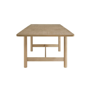 A beige Bloomfield dining table with a butterfly extension, made of wood, with rounded corners and tubular  left site .