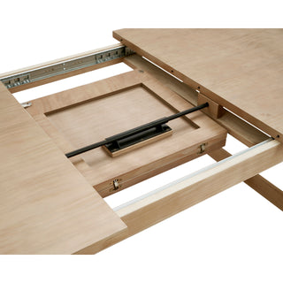 A beige Bloomfield dining table with a butterfly extension, made of wood, with rounded corners and tubular open sefty gard.