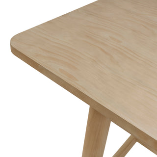 A beige Bloomfield dining table with a butterfly extension, made of wood, with rounded corners and tubular  right site ornar