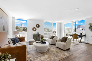Modern living room with large windows, furniture, and decor.