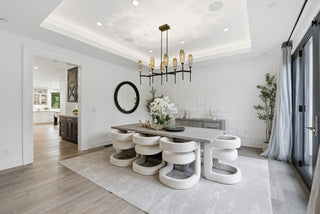 Modern dining room with a stylish table and chairs, chandelier, and decorative elements.