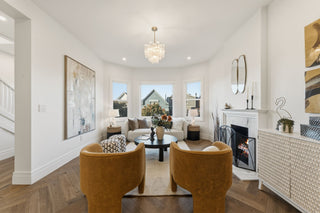 Modern living room with white walls, wooden floor, and decorative elements.