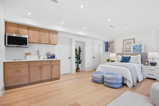 Modern kitchen and bedroom with wooden cabinets and white walls.