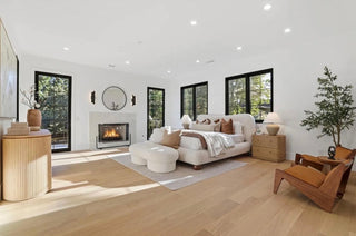 A cozy bedroom featuring a fireplace and warm wood floors, creating an inviting atmosphere.