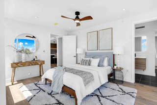 Modern bedroom with a bed, nightstands, and decorative elements.