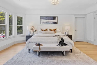 Modern bedroom with a bed, bench, and decor elements.