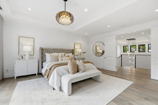 A cozy bedroom showcasing white walls and natural wood floors, providing a fresh and tranquil environment