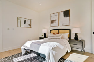 Modern bedroom with a bed, nightstands, and abstract art on the wall.