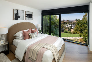 Modern bedroom with a large window view of greenery