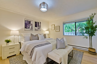Neatly arranged bedroom with a bed, nightstands, and decor.