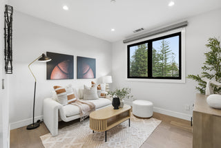 A cozy living room featuring a couch, a chair, and a large window allowing natural light to enter