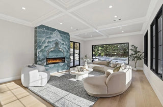 A cozy living room featuring a fireplace and a large window allowing natural light to fill the space.