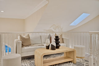 Living room with a white sofa, wooden coffee table, and decorative items.