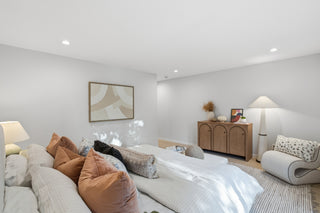 Modern bedroom with a bed, lamp, and dresser.