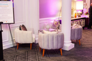 Decorative interior with plush chairs and a purple-lit wall.