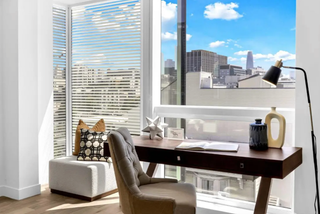 Modern home office with a desk, chair, and cityscape view.