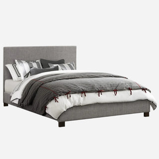A full-size platform bed upholstered in gray fabric, including a headboard, footboard, slats, and rails, with bedding and pillows on top.