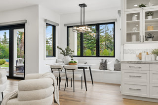 A modern kitchen and dining area featuring sleek white cabinets and contemporary furnishings.