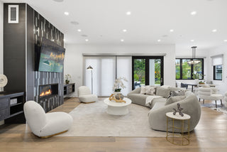 A modern living room featuring a cozy fireplace and a flat-screen television on the wall.