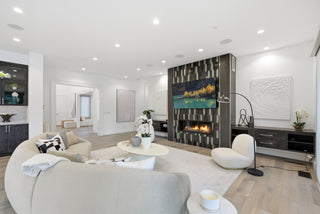 A modern living room featuring a cozy fireplace and a large, colorful painting on the wall.