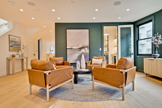 Modern living room with brown leather chairs, a coffee table, and decorative items.
