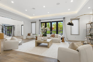 A modern living room with white furnishings and a spacious glass door that opens to a patio.