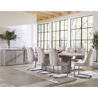 A modern rectangular dining table in a mineral gray finish with nickel-plated pulls, surrounded by matching chairs in a bright, well-lit dining room.