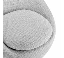 A modernist style fabric swivel accent chair with a round silhouette, upholstered in a light color, showing a side and partial front view and Font Fabrics .
