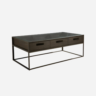 A rectangular Bradley coffee table with three drawers, featuring a chevron-matched pine veneer surface in a double fudge finish, with a metal frame base in bronze color.