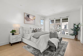 Modern bedroom with a bed, nightstands, and large windows.