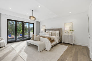 A spacious bedroom featuring a large bed and a sliding glass door leading to an outdoor area.