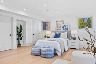 Modern bedroom with a bed, side tables, and decorative items.
