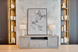 Modern living room with a TV stand, abstract painting, and decorative shelves.