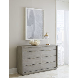 An Oxford Eight-Drawer Dresser in Mineral finish with nickel-plated pulls, placed against a neutral background, accompanied by a decorative mirror and a small lamp on its right side.