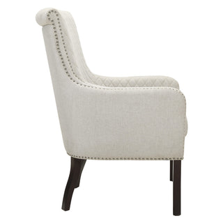 An elegant gray upholstered accent chair with a quilted textured fabric, diamond-stitched back, and nailhead trim, seated on a rich coffee-finished wooden frame left6 site .