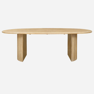 An oval-shaped dining table with a solid wood finish and crescent-shaped legs, having a ridged wood texture.