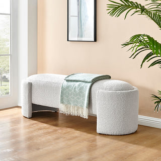 An oval-shaped fabric bench with a smooth, soft texture in a light color, likely white or light gray  setup