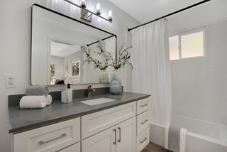 Bathroom with vanity, mirror, and shower curtain.