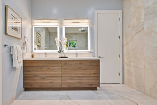 Bathroom with wooden vanity, mirrors, and towels.