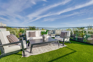 Outdoor patio with furniture and plants on a rooftop deck.