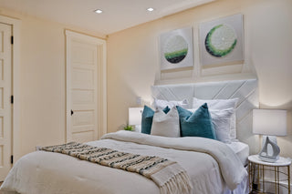Neatly made bed with decorative pillows in a bedroom setting.