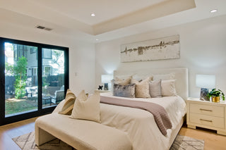 Bedroom with blue bedding, in the  wooden nightstands, and a window