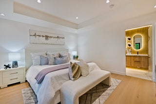 Modern bedroom with a bed, nightstands, and a bathroom in the background.