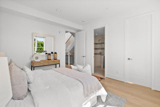 Modern bedroom with a bed, dresser, and mirror.