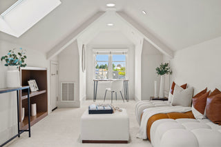 Modern bedroom with a bed, desk, and window view of a cityscape.