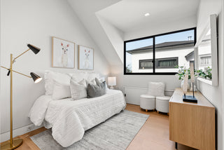 Modern bedroom with a bed, lamp, and large window.