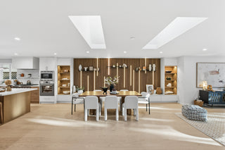 Modern kitchen and dining area with wooden flooring and white walls.