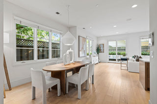 Modern dining room with wooden table and chairs in a bright, well-lit home.